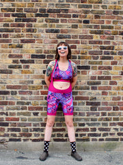 Rouleur Leggings view B - image of woman in brightly coloured bib shorts standing against a brick wall