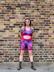 Rouleur Leggings view B - image of woman in brightly coloured bib shorts standing against a brick wall 